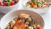 Salmon, Tofu and Noodles and Fresh Strawberries served in large white bowls