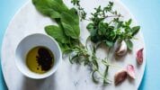 Fresh herbs and oils on granite plate