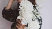 woman holding bouquet of white flowers