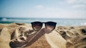 Sunglasses perched in the sand on the beach