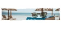 Sunglasses on top of a book at the beach